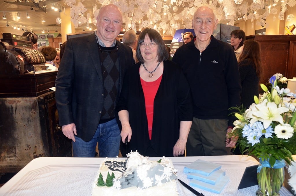 Mayor Mark McKee (left) helped curator Cathy English and guest of honour Peter Schaerer with the cake duties. Photo: Aaron Orlando/Revelstoke Mountaineer