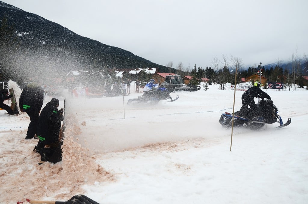 Revelstoke Snowmobile Club president Daniel Kellie takes shelter behind an improvised shield at the start line. The shield keeps the snow in place so the starting area doesn't get stripped to the ground. Aaron Orlando/Revelstoke Mountaineer