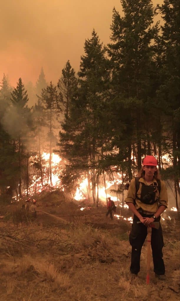 Wildland firefighter Joshua Day in front of a contained fire