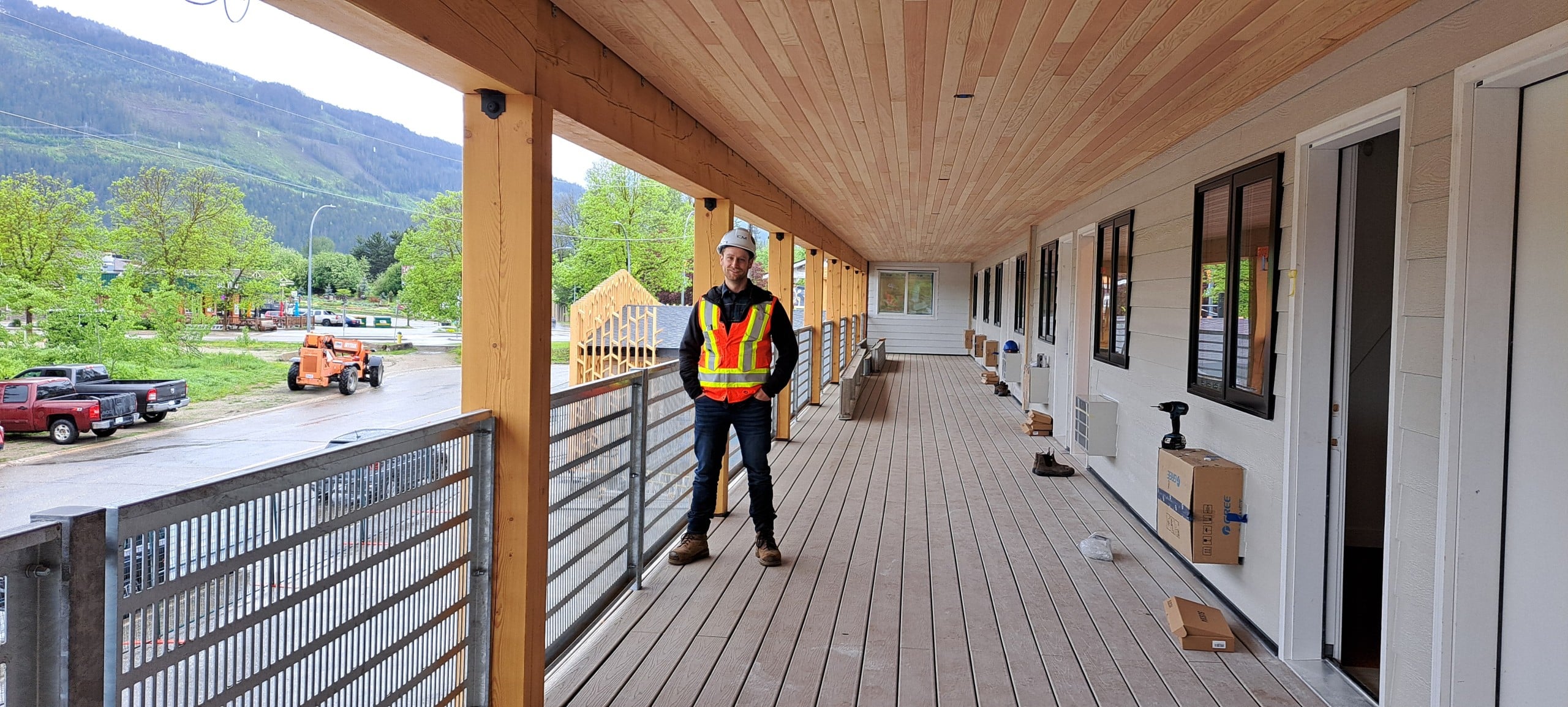 VRGE Revelstoke co-founder Matt Crowley in construction safety gear standing on the second floor balcony of VRGE Revelstoke