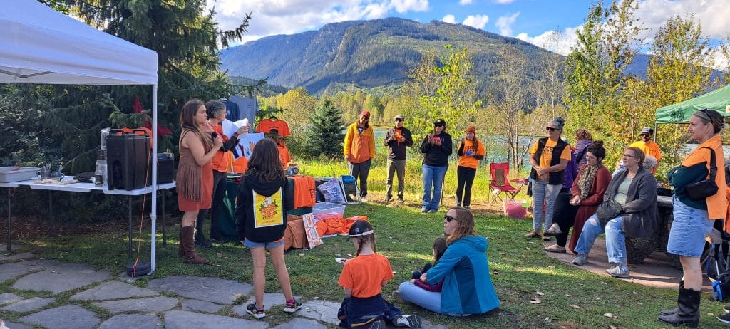 Orange Shirt Day 2024 participants gather for a story at the Worker's Memorial in Revelstoke's Centennial Park